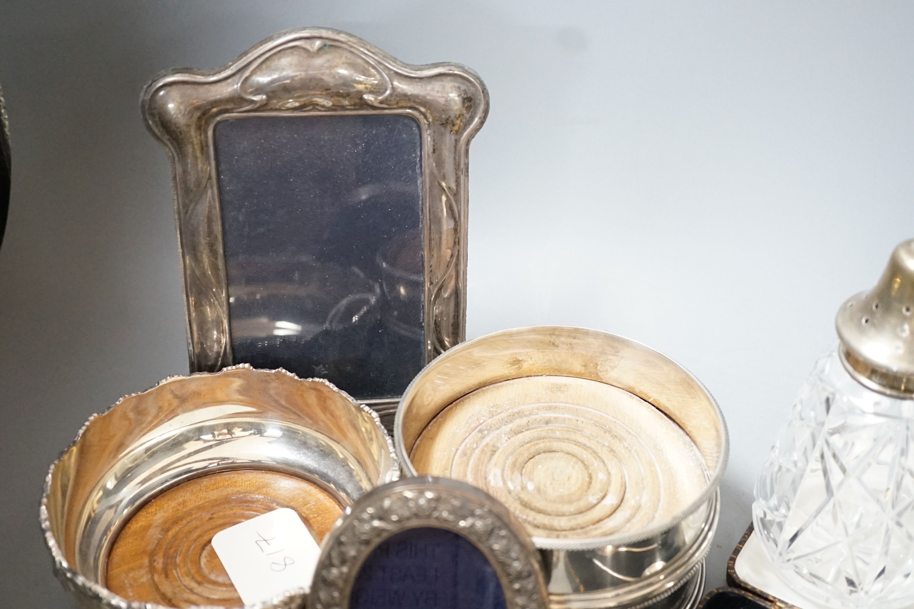 Mixed small silver including a pair of modern silver mounted wine coasters, 12.6cm, two silver mounted photograph frames, silver dish by William Comyns, three silver bonbon dishes, two sets of six silver teaspoons, a sil